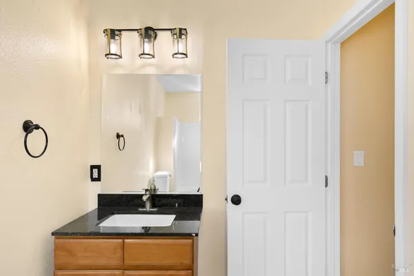 a bathroom with a granite countertop sink and a mirror