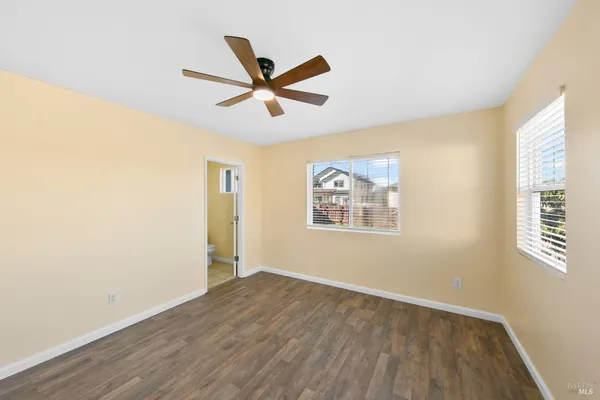 a view of a big room with wooden floor and windows