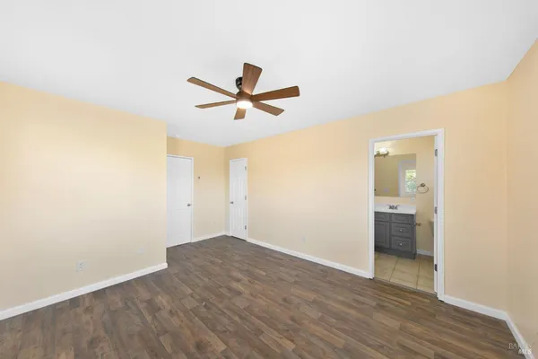 a view of a big room with wooden floor and windows