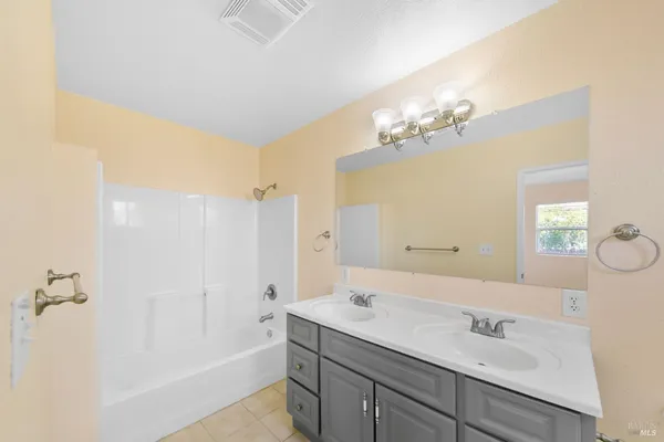 a bathroom with a tub sink and mirror