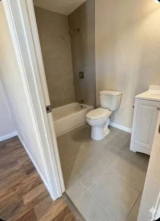 a white toilet sitting next to a bath tub