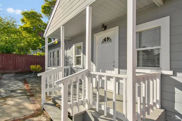 a view of a house with a yard and wooden fence
