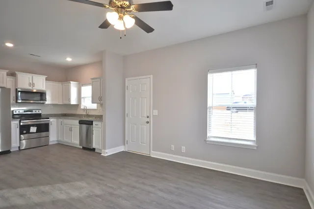 a view of kitchen with refrigerator stove microwave and cabinets