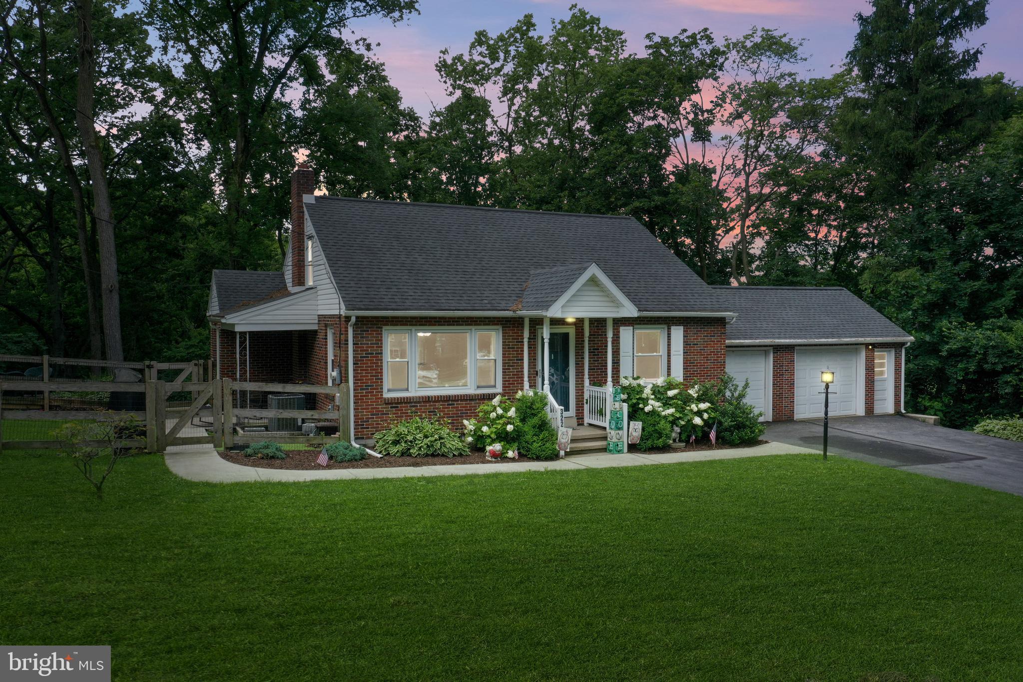 a front view of a house with a garden and plants