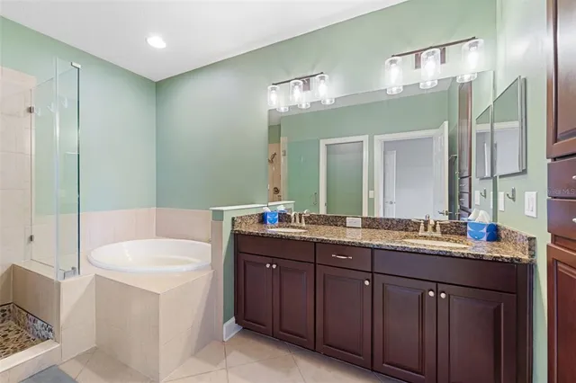 a bathroom with a double vanity sink mirror and bathtub