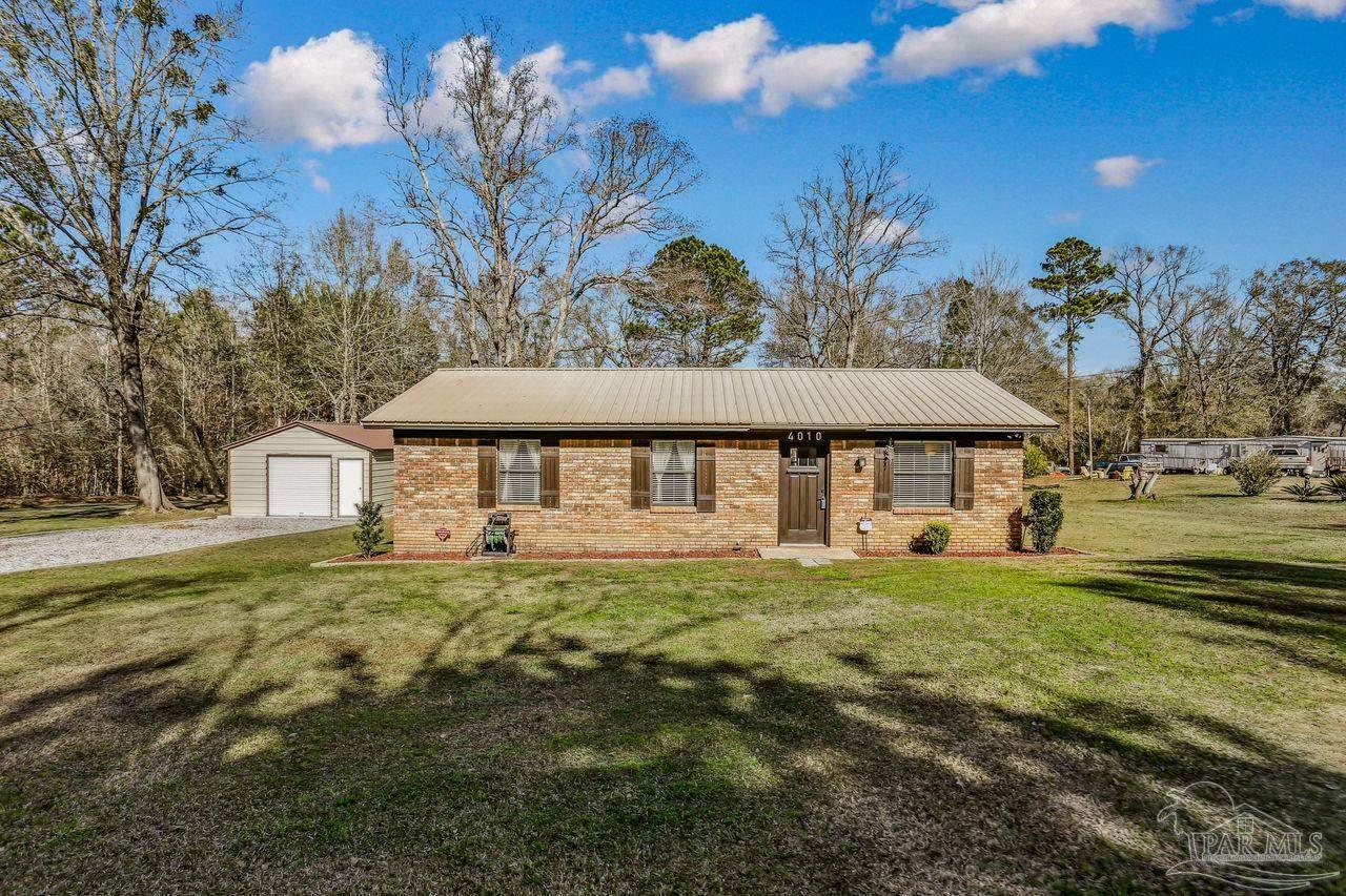 4010 Wyndham Road Century, FL 32535 - Photo 1 of 25 a front view of a house with garden