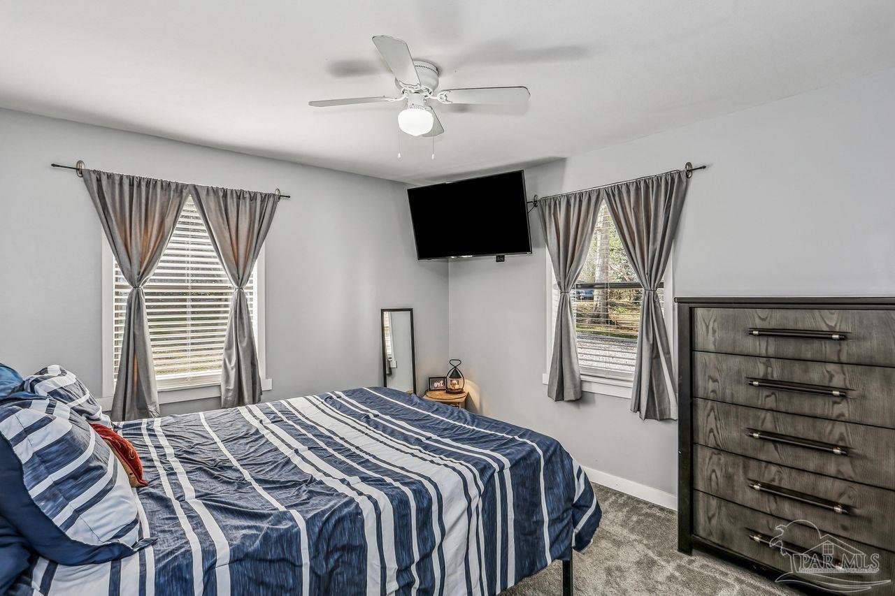 4010 Wyndham Road Century, FL 32535 - Photo 13 of 25 a bedroom with a bed a flat screen tv and a window