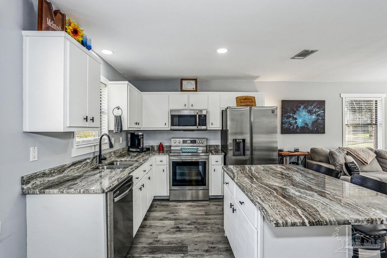 4010 Wyndham Road Century, FL 32535 - Photo 9 of 25 a large kitchen with stainless steel appliances granite countertop a stove sink and cabinets