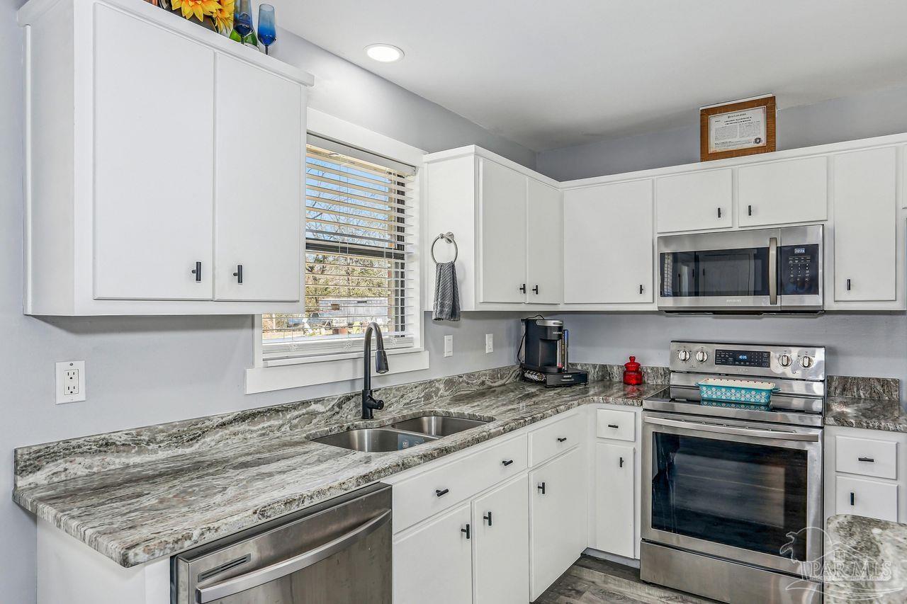 4010 Wyndham Road Century, FL 32535 - Photo 10 of 25 a kitchen with granite countertop a stove sink and cabinets
