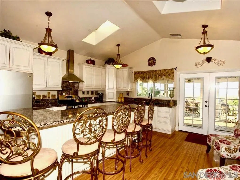 18259 Chablis Road Ramona, CA 92065 - Photo 15 of 24 a view of a dining room and livingroom with furniture wooden floor a chandelier