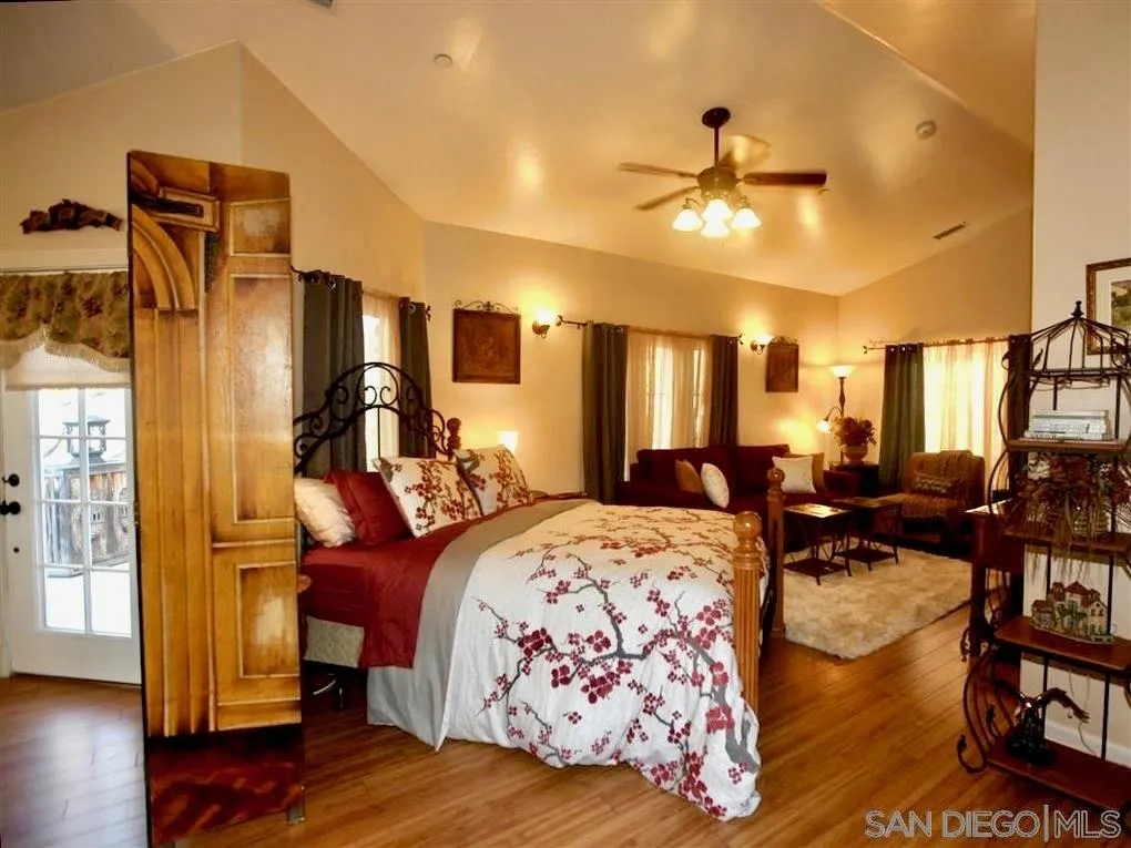18259 Chablis Road Ramona, CA 92065 - Photo 16 of 24 a bed room with a bed and a chandelier