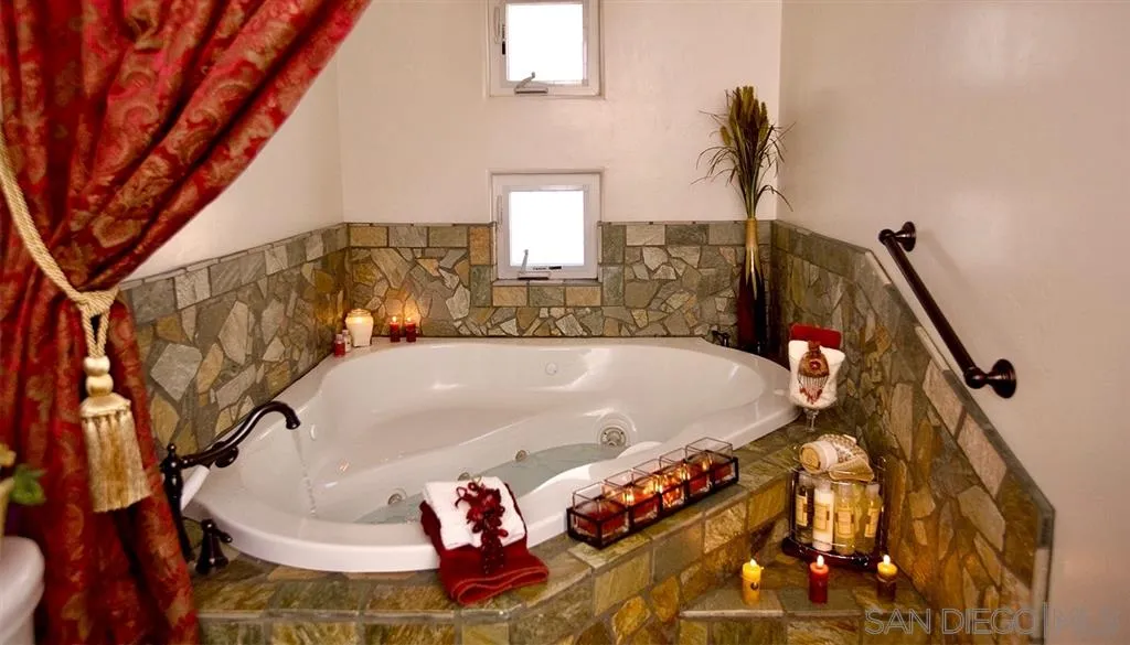 18259 Chablis Road Ramona, CA 92065 - Photo 17 of 24 a bath tub sitting next to a blue sink and a window