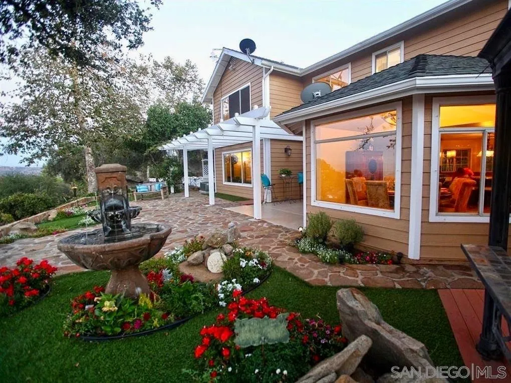 18259 Chablis Road Ramona, CA 92065 - Photo 2 of 24 a front view of a house with fountain and garden