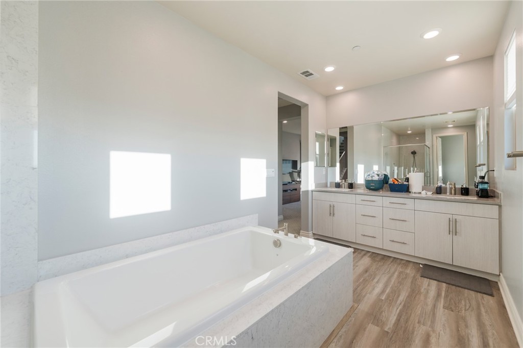102 Spectacle Irvine, CA 92618 - Photo 24 of 40 a spacious bathroom with a bathtub a double vanity sink and mirror