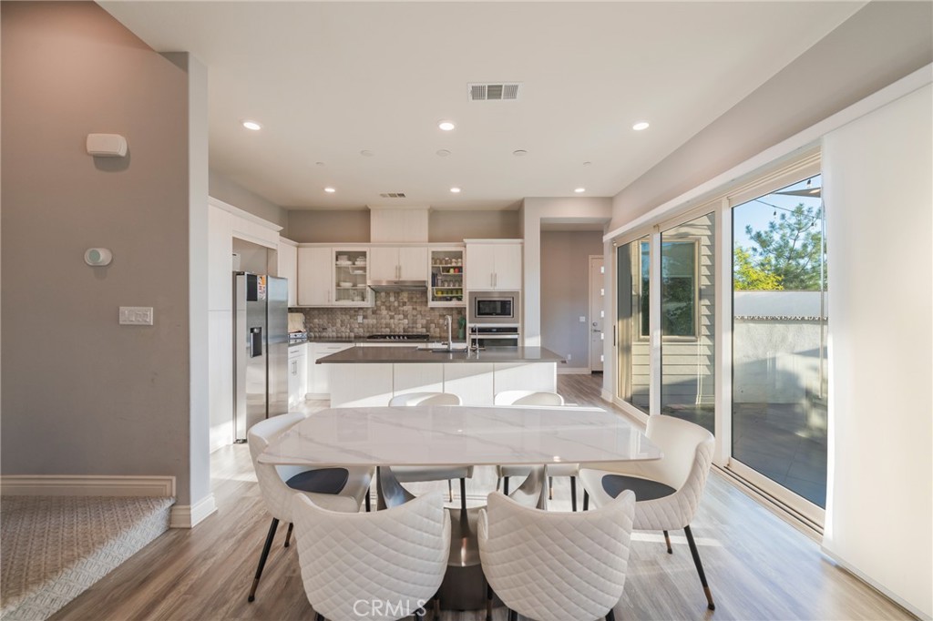 102 Spectacle Irvine, CA 92618 - Photo 7 of 40 a view of a dining room with furniture window and wooden floor