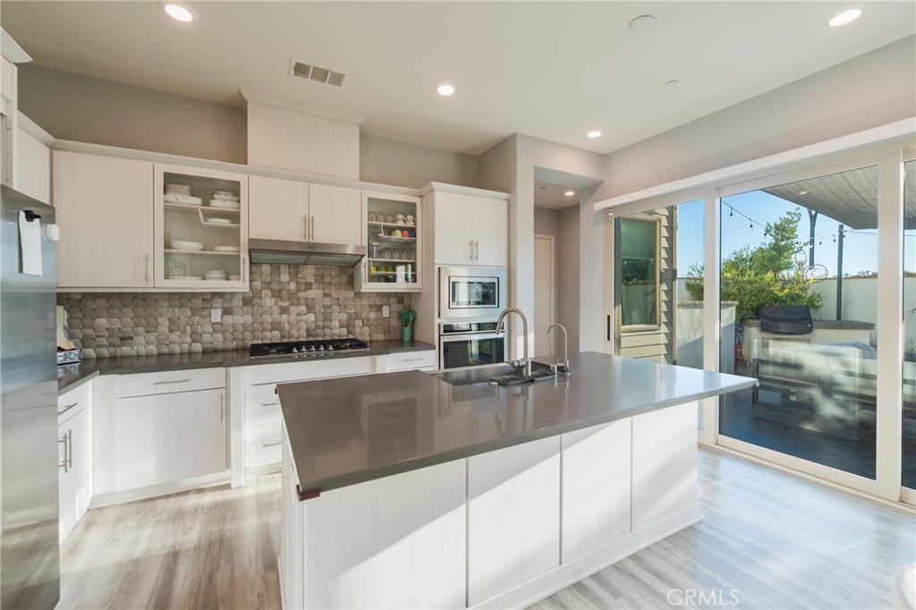 102 Spectacle Irvine, CA 92618 - Photo 9 of 40 a large kitchen with kitchen island a large window a sink and cabinets