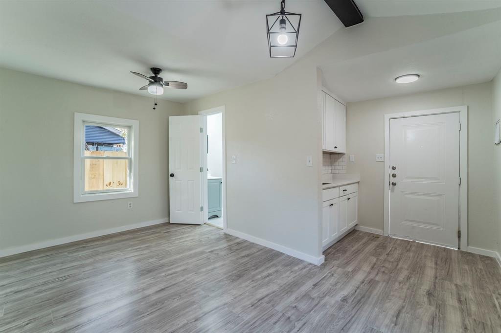 5914 Victor Street Dallas, TX 75214 - Photo 17 of 32 a view of an empty room with a window and wooden floor