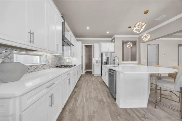 a large kitchen with stainless steel appliances kitchen island granite countertop a large counter top and white cabinets