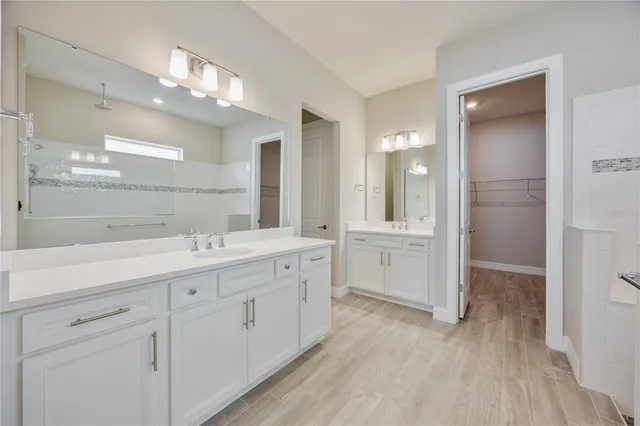 a bathroom with a double vanity sink and mirror