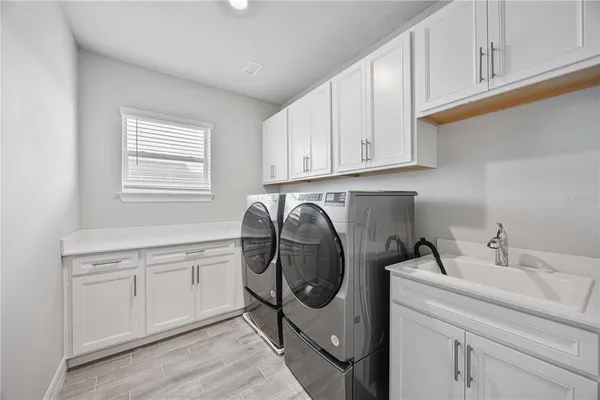 a utility room with sink dryer and washer