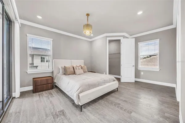 a bedroom with a bed and a chandelier