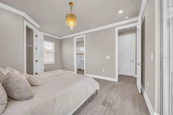 a bedroom with a large bed and a chandelier