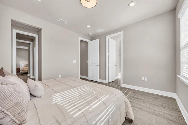 a spacious bedroom with a bed and a window