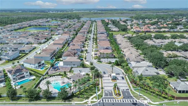 an aerial view of residential houses with outdoor space and trees