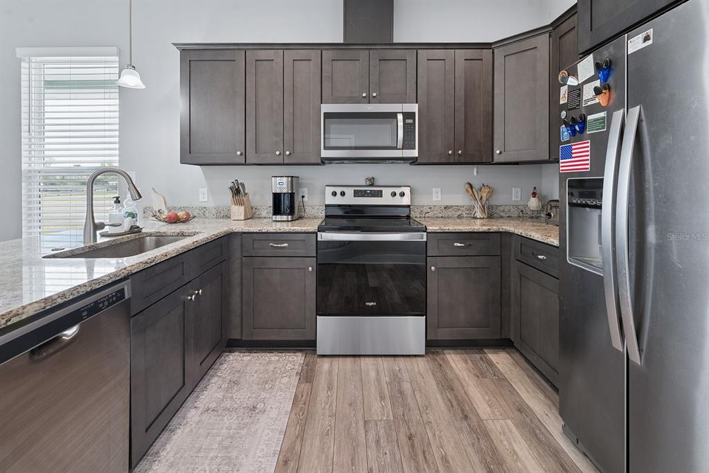 6095 Southwest 82nd Place Trenton, FL 32693 - Photo 24 of 44 a kitchen with stainless steel appliances granite countertop a stove a sink dishwasher and a refrigerator