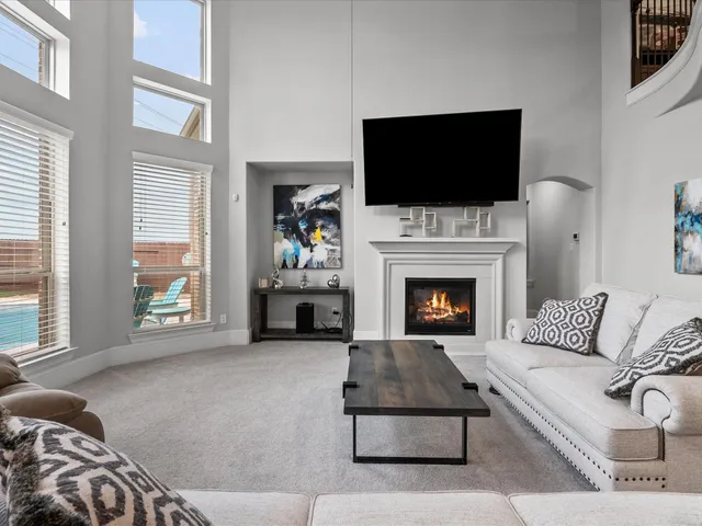 a living room with furniture a flat screen tv and a fireplace
