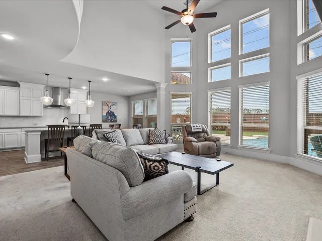 a living room with furniture and floor to ceiling windows