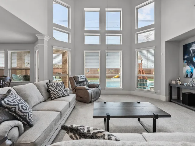 a living room with furniture a table and large window
