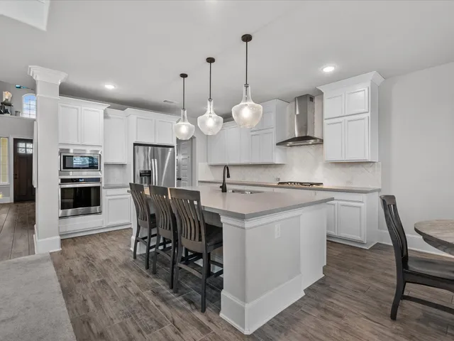 a kitchen with a dining table chairs sink and cabinets