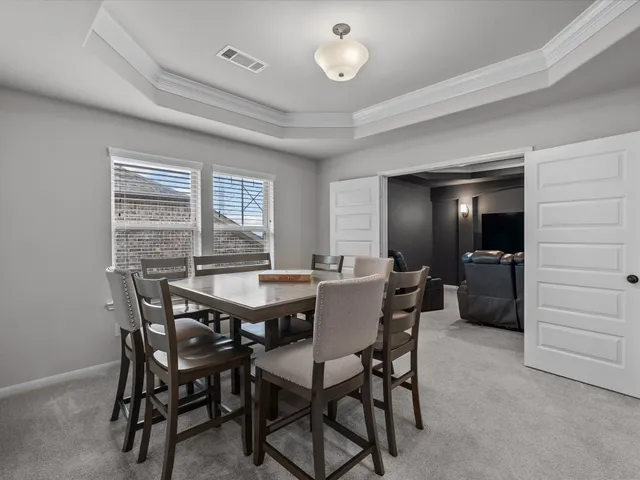 a dining room with a wooden table and chairs