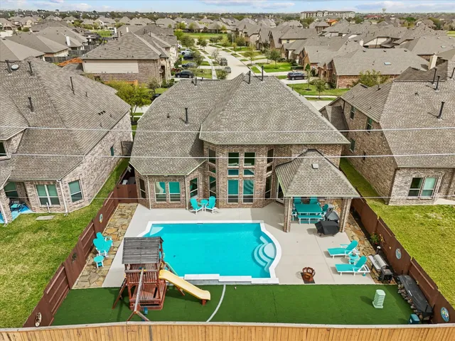 an aerial view of residential houses with outdoor space and swimming pool