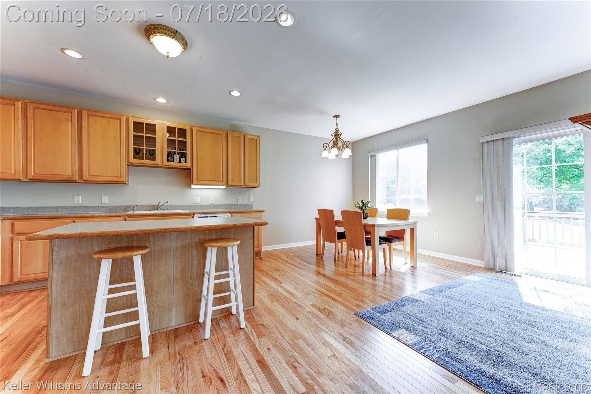 41647 Mitchell Road Novi, MI 48377 - Photo 18 of 43 Open-concept kitchen and dining area featuring natural wood cabinetry, a central island with a breakfast bar, recessed lighting, and wood-finish flooring