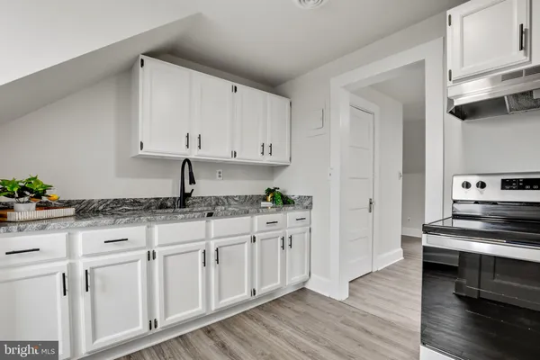 a kitchen with granite countertop white cabinets and white appliances