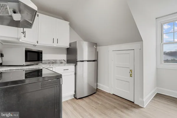 a kitchen with a refrigerator stove and white cabinets