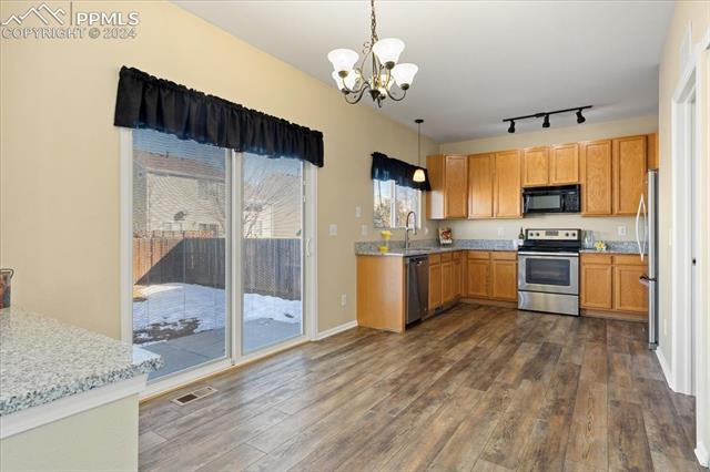 7655 Coffee Road Peyton, CO 80831 - Photo 9 of 31 Kitchen with pendant lighting, a notable chandelier.