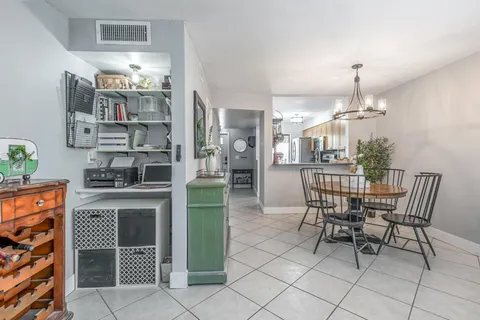 a dining room with furniture a chandelier and kitchen view