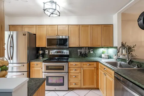 a kitchen with stainless steel appliances granite countertop a refrigerator stove and sink