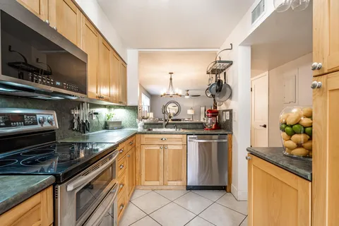 a kitchen with stainless steel appliances granite countertop a sink and a stove