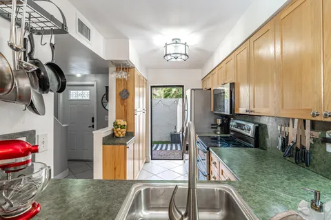 a kitchen with stainless steel appliances granite countertop a sink and a refrigerator