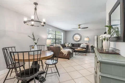 a living room with furniture a chandelier and a window