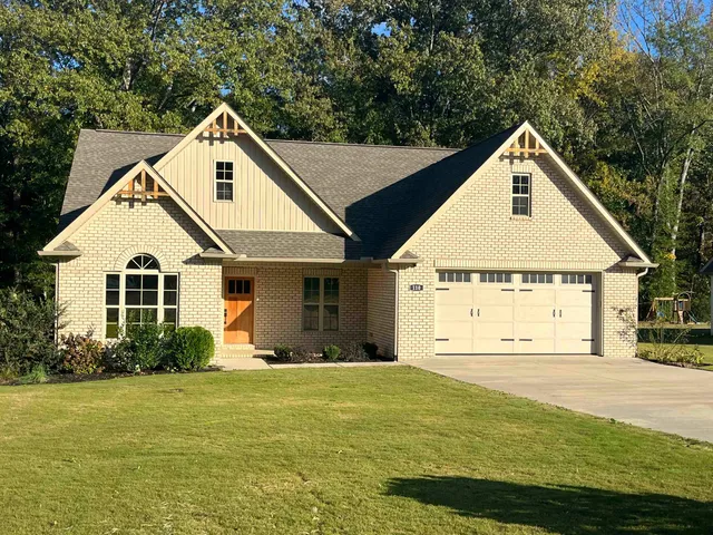 a view of a white house with yard and plants