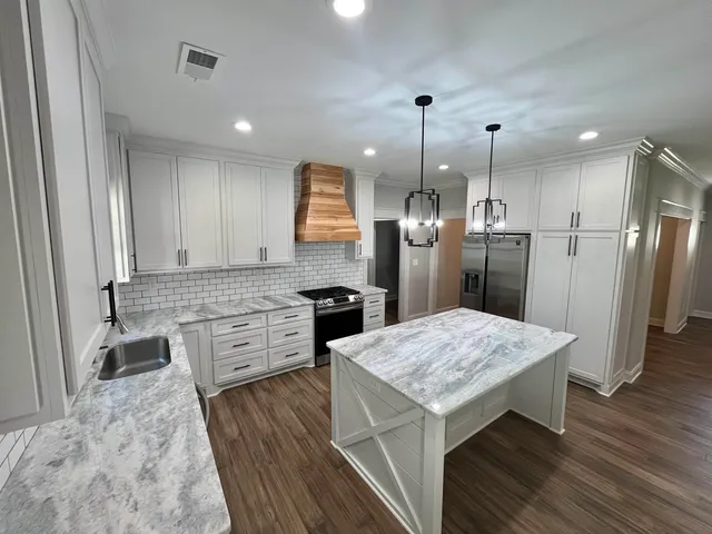 a kitchen with a refrigerator a sink and wooden floor