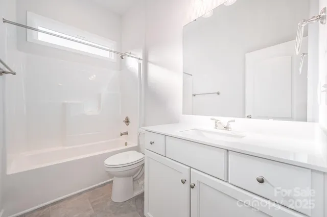 a bathroom with a granite countertop sink a toilet and a bathtub