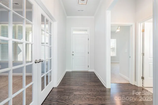 a view of a hallway with wooden floor and windows