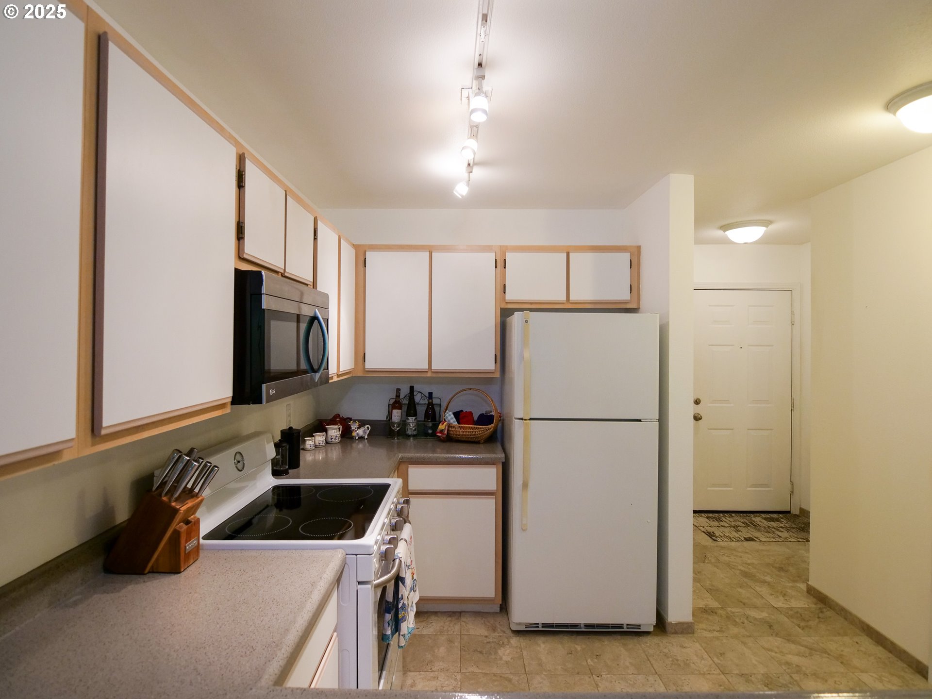 5130 Southwest Multnomah Boulevard, Unit B Portland, OR 97219 - Photo 22 of 36 a kitchen with a refrigerator a stove a microwave and cabinets