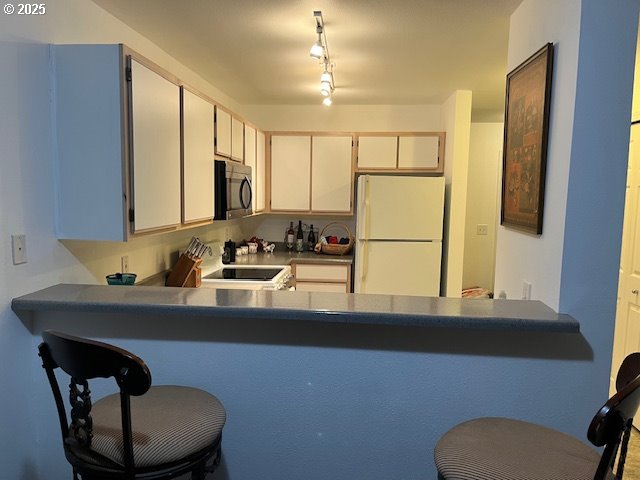5130 Southwest Multnomah Boulevard, Unit B Portland, OR 97219 - Photo 4 of 36 a kitchen with stainless steel appliances a sink and a refrigerator